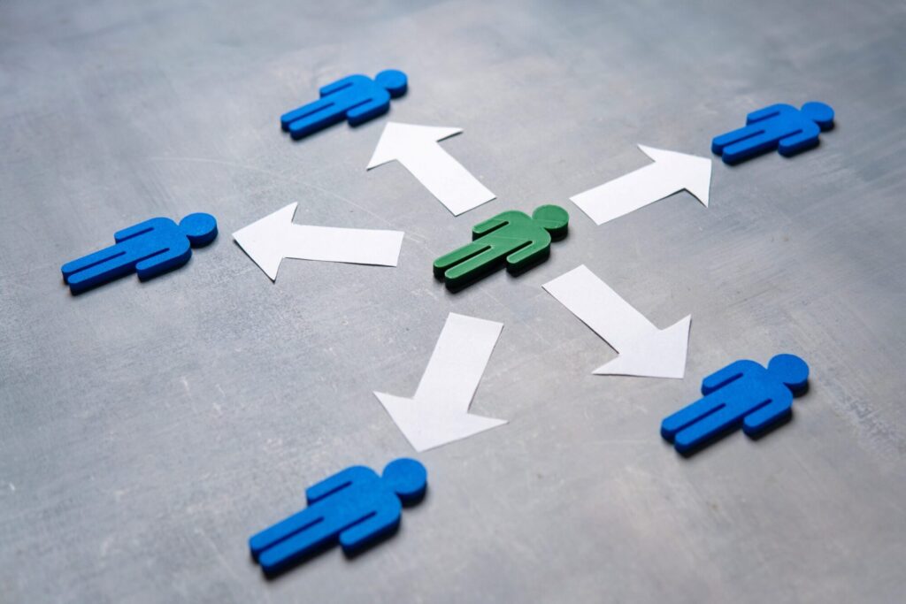 A central green stick figure with white arrows pointing outward to four surrounding blue stick figures on a gray background.