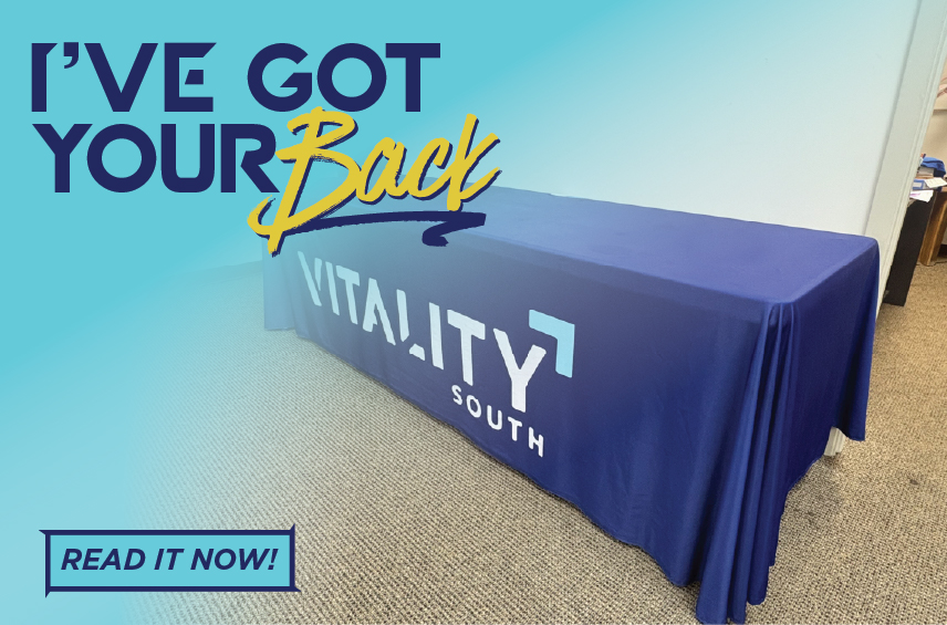 Graphic for the article 'I've Got Your Back' featuring a Vitality South branded event table and tablecloth.